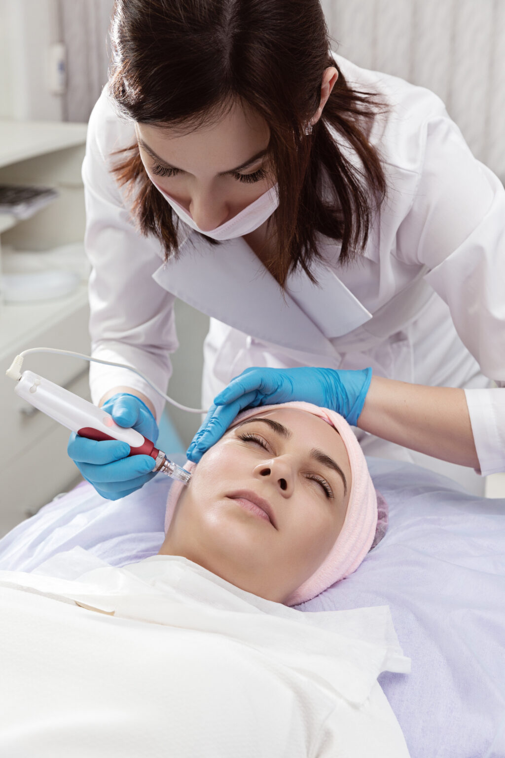 Woman receiving professional laser skin resurfacing treatment at a dermatology clinic