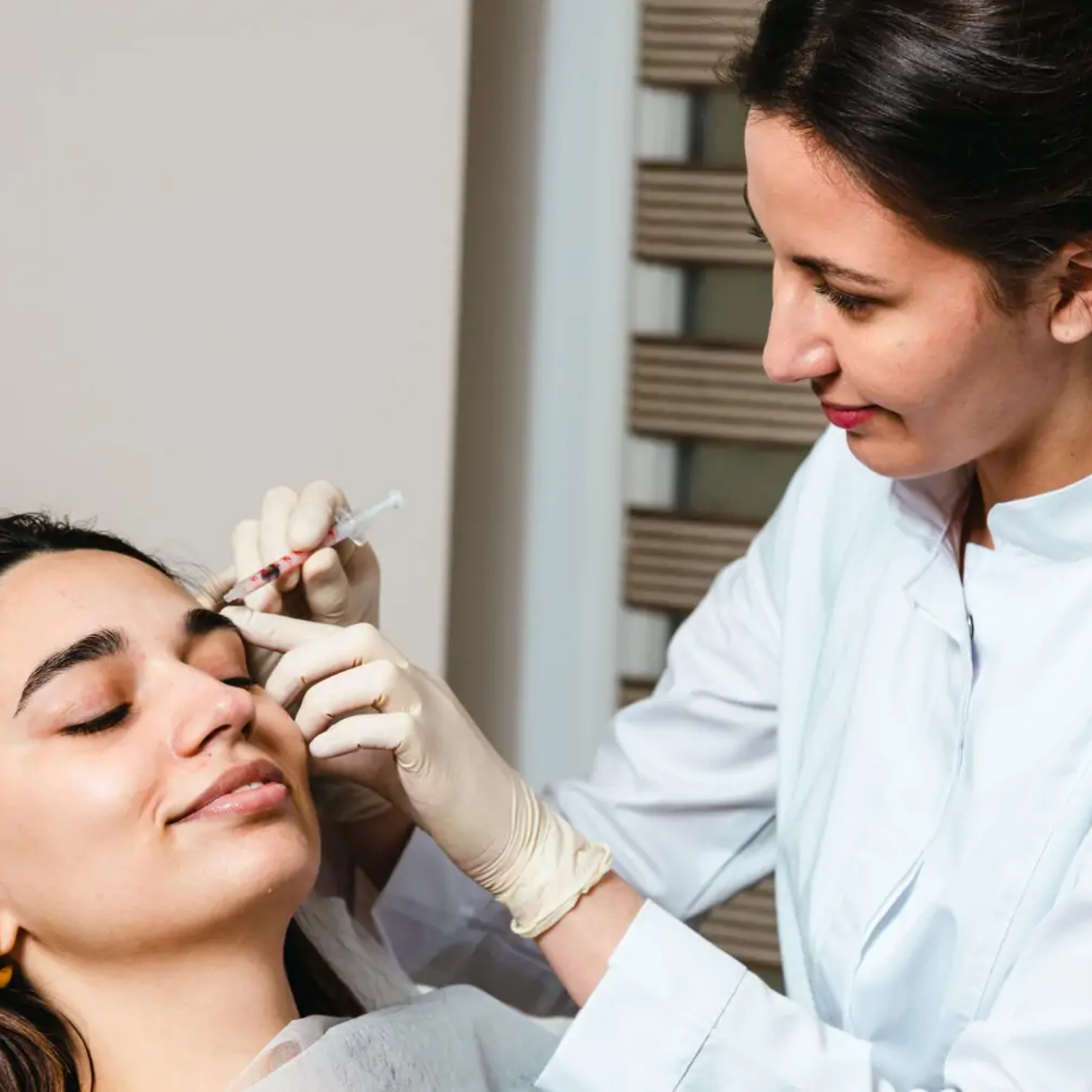 : Dermatologist performing Botox and filler treatment at Reveal Clinics