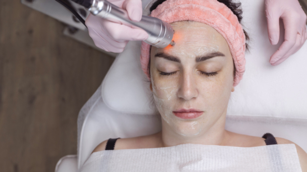 Dermatologist performing fractional CO₂ laser resurfacing treatment at Reveal Clinics Riyadh.