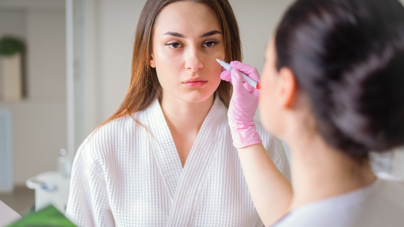 Female dermatologist examining patient’s skin during consultation at Reveal Clinics Riyadh.