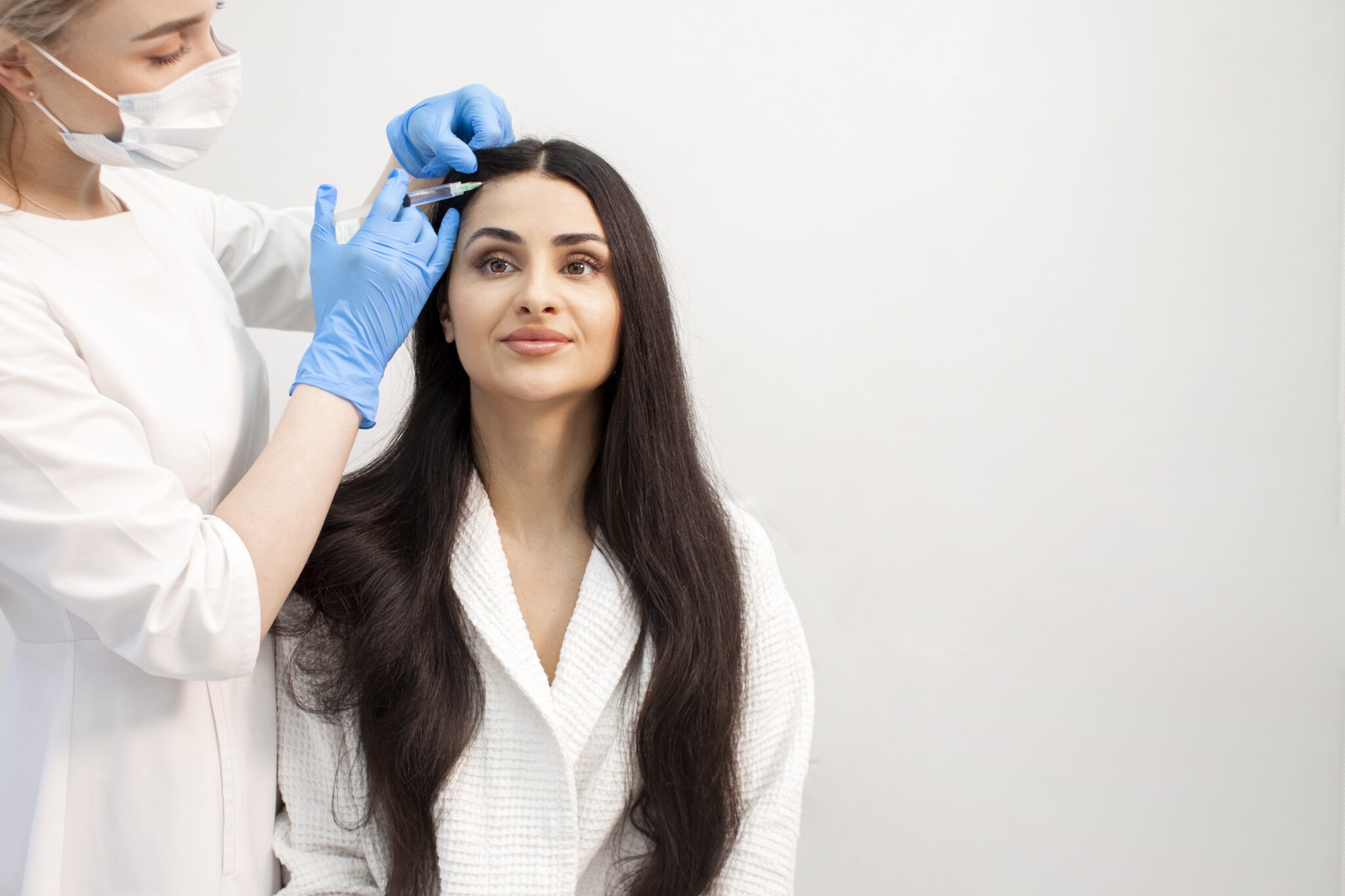 Dermatologist performing Exosome scalp treatment for hair regrowth at Reveal Clinics Riyadh.
