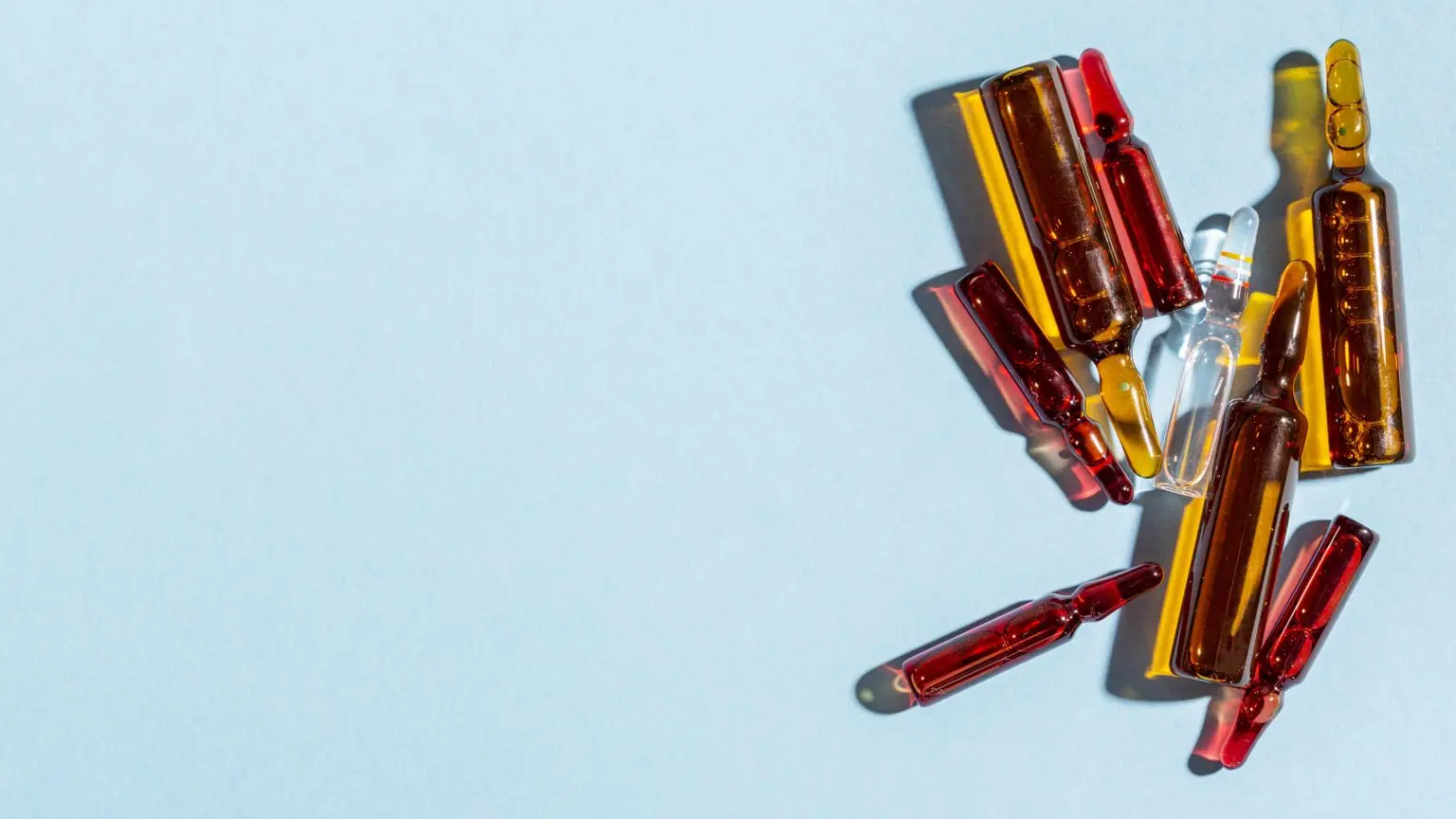 Glass ampoules containing salmon DNA skin booster serums in amber and clear tones, arranged on a minimalist light background.