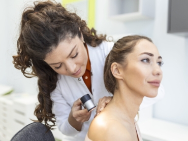 Dermatologist performing digital mole assessment